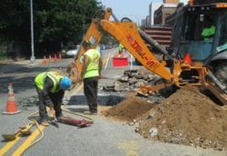 Excavating with backhoe for sewer line repair