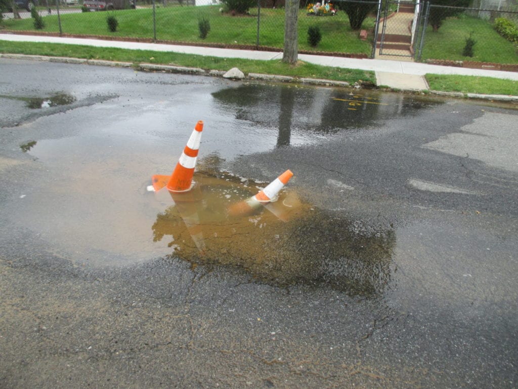 Water main leaks in street from faulty repair