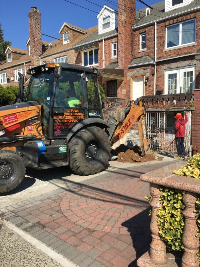 Digging with backhoe for water main installation 