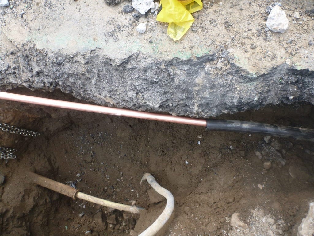 Copper water main installed inside of plastic tubing