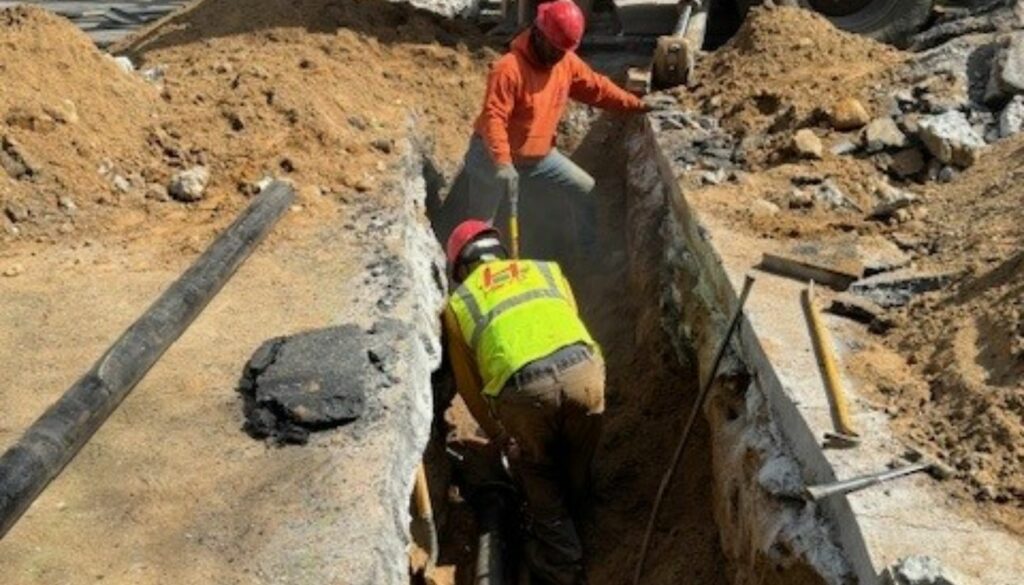 Team operating heavy-duty equipment at local worksite – alt: sewer line installation near me