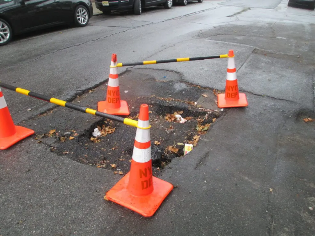 Roadway sinkhole, showing damaged pavement and underlying void.